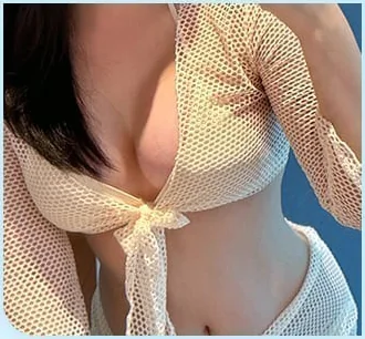 隆乳術後披著透膚罩衫的照片